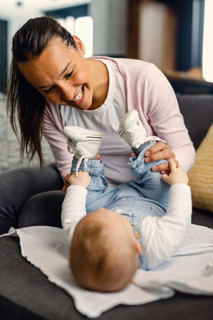 Young mother having fun with her baby at home.